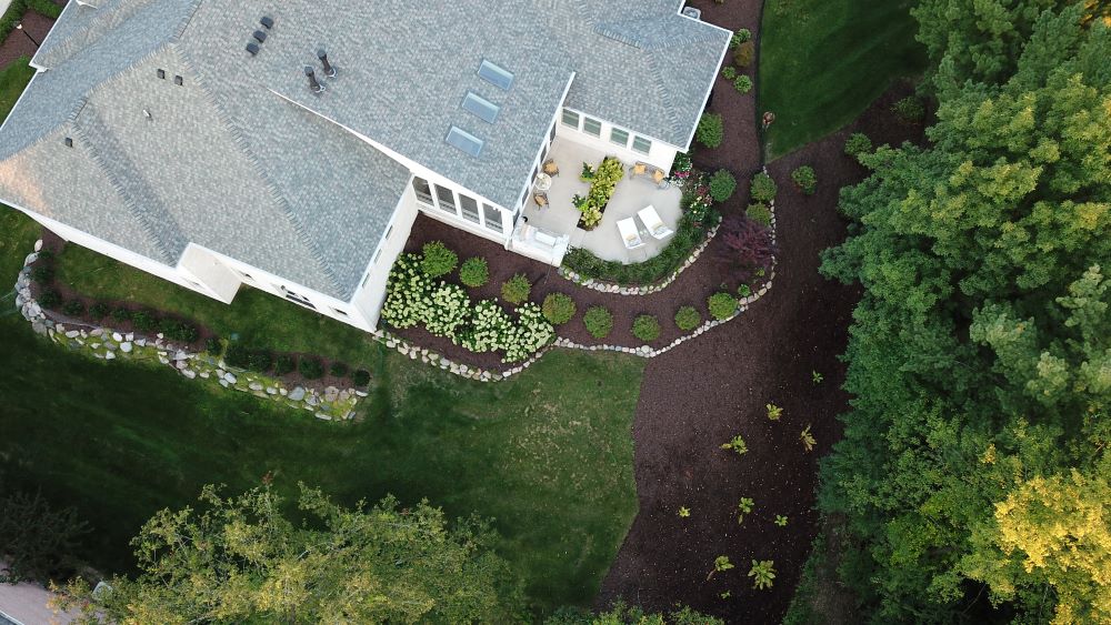 Aerial view of a large home with recently updated landscaping