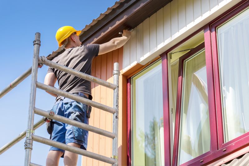 Maintenance worker painting the side of a building